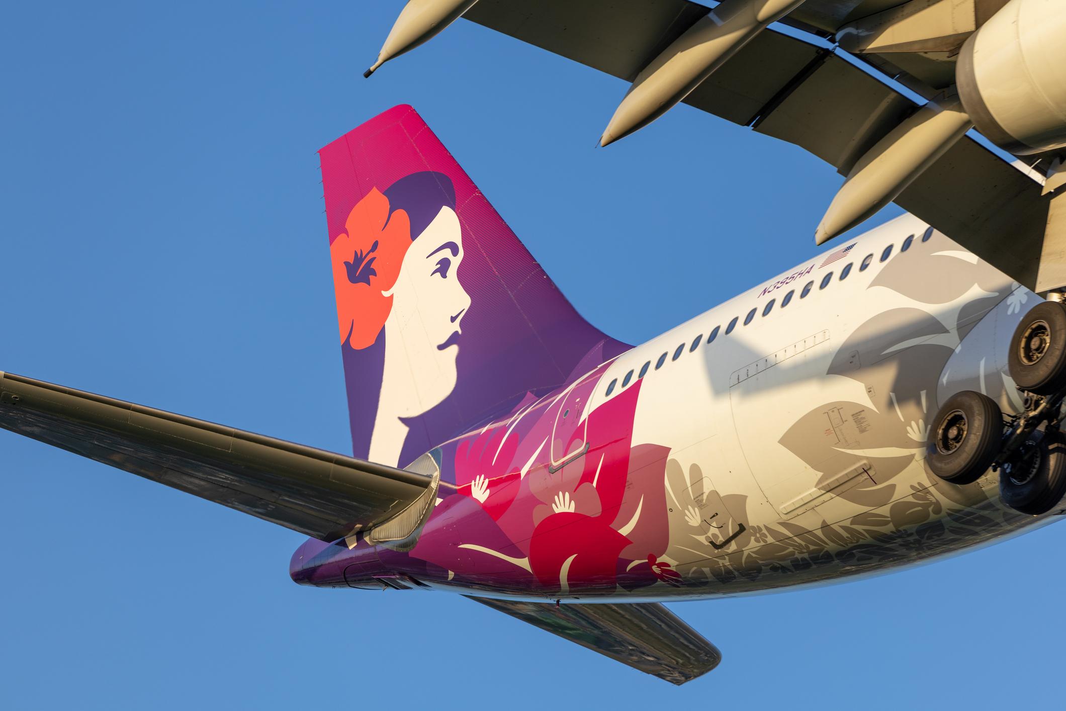 A Hawaiian Airlines Airbus A330-243 plane, registration N395HA, landing from the north at Sydney Kingsford Smith Airport as flight AS851 from Honolulu. The starboard wing and winglet casts a shadow on the fuselage. This image was taken from near Nigel Love Bridge, Mascot on a hot and sunny evening approaching sunset on 23 January 2026.