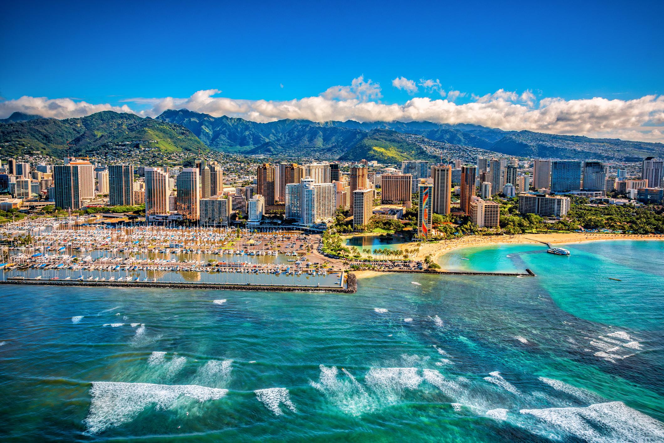 The beautiful skyline of Honolulu, Hawaii on the island of Oahu shot via helicopter from over the ocean from an altitude of about 600 feet.