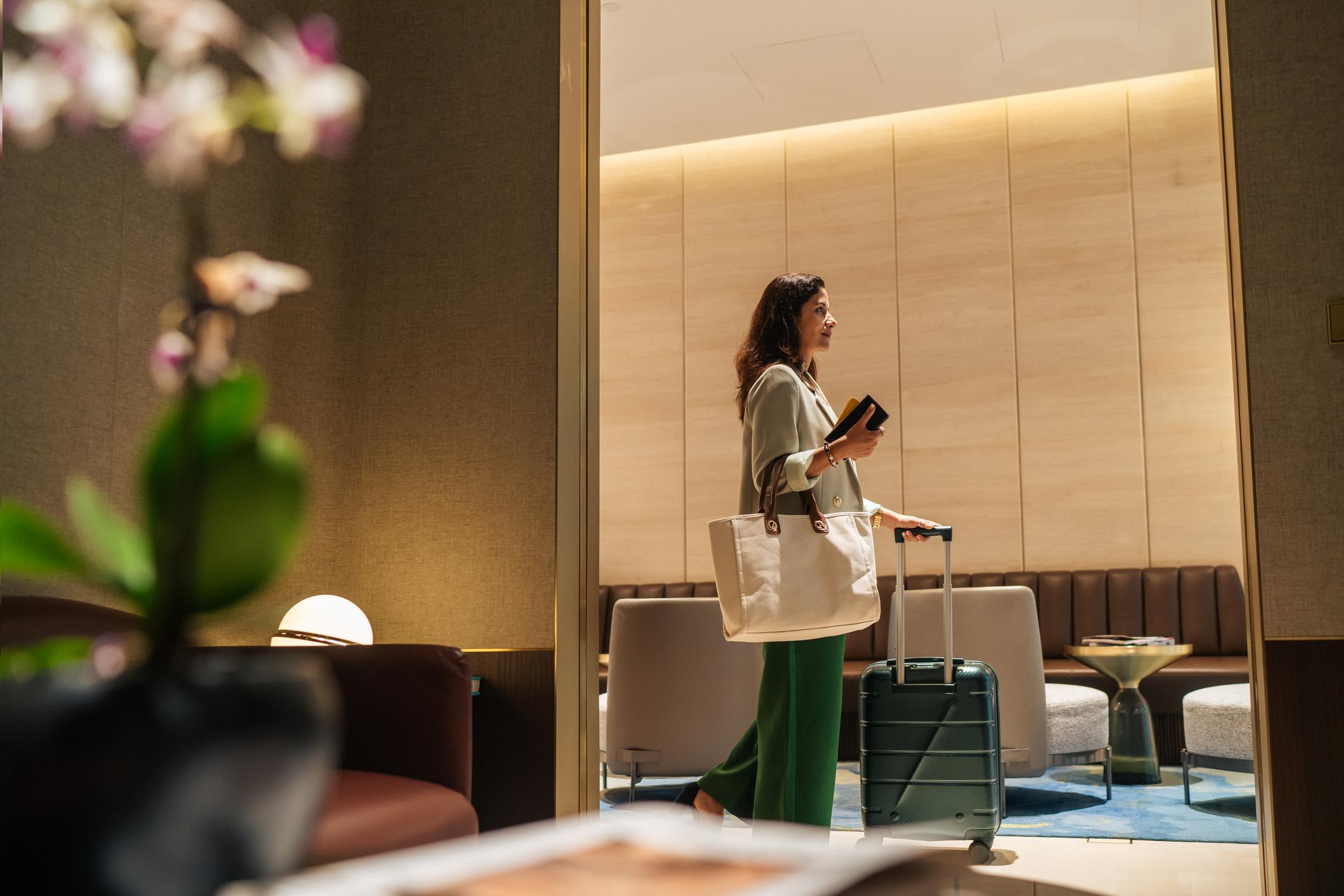 Well dressed affluent Asian business traveler checking into an exclusive airport lounge