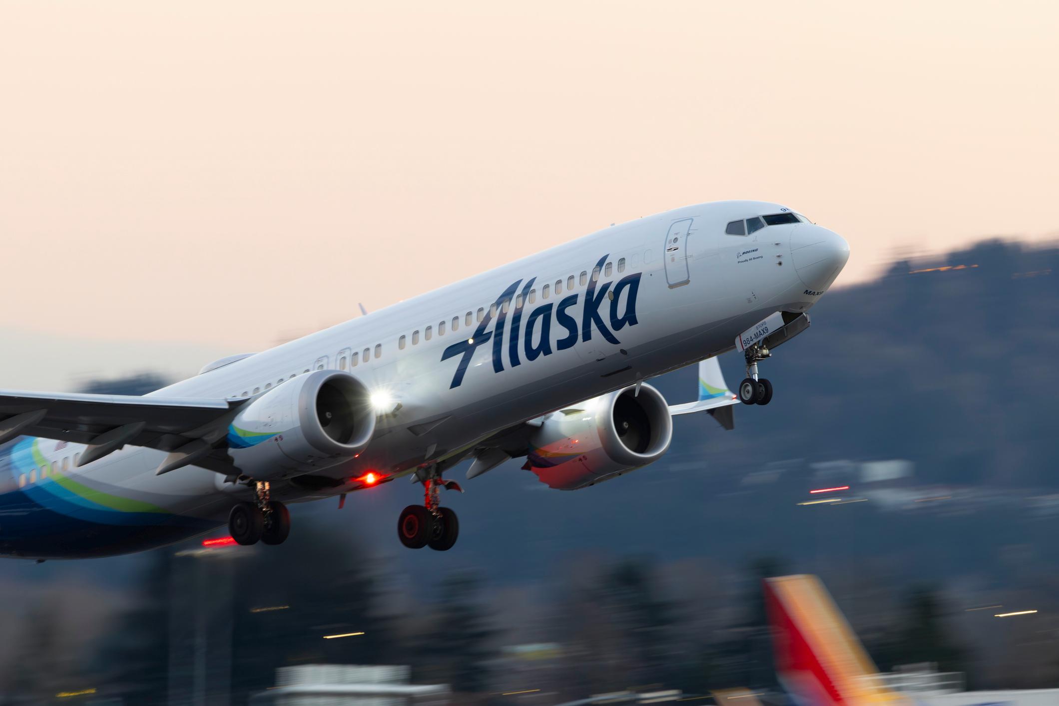An Alaska Airlines Boeing 737 Max 900 takes off at dusk from Portland International Airport.