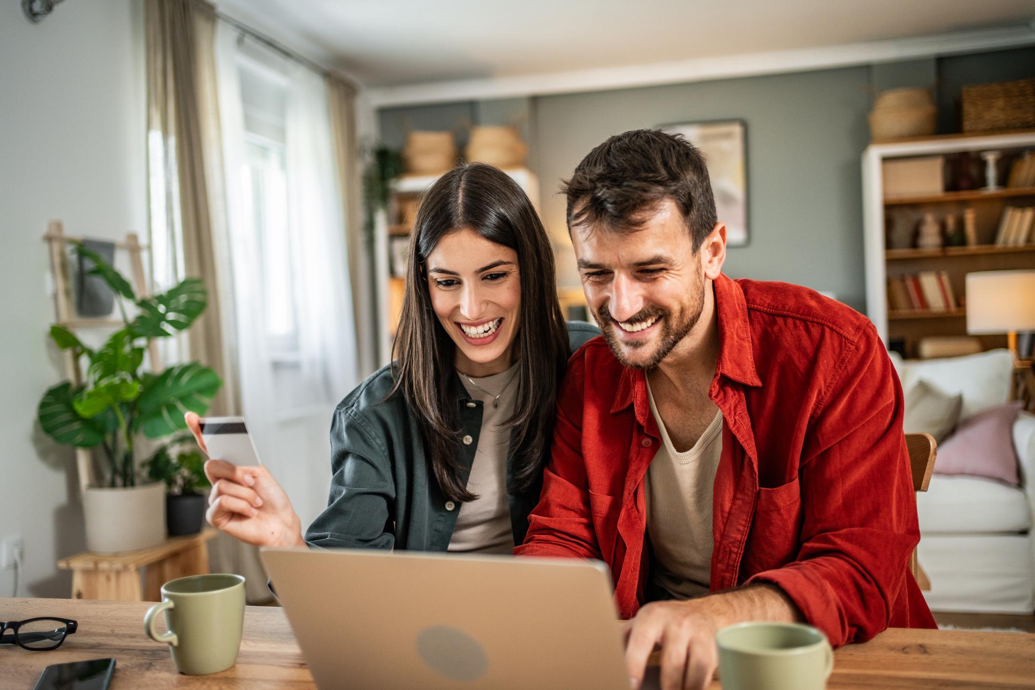 Young couple shopping online at home. Young couple shopping online with credit card and laptop.