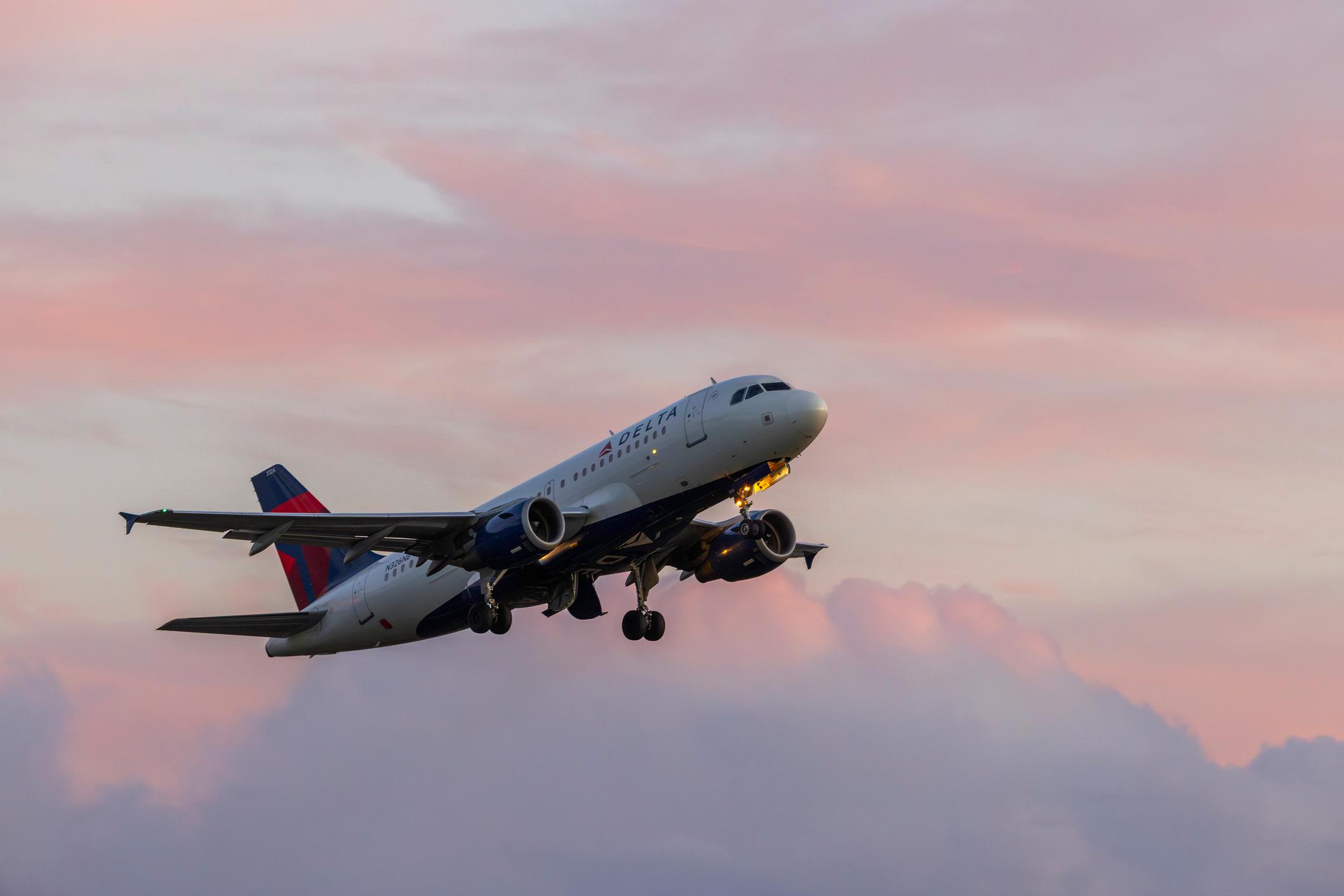 A Delta Airlines Airbus A319 takes off at sunset from Portland International Airport.