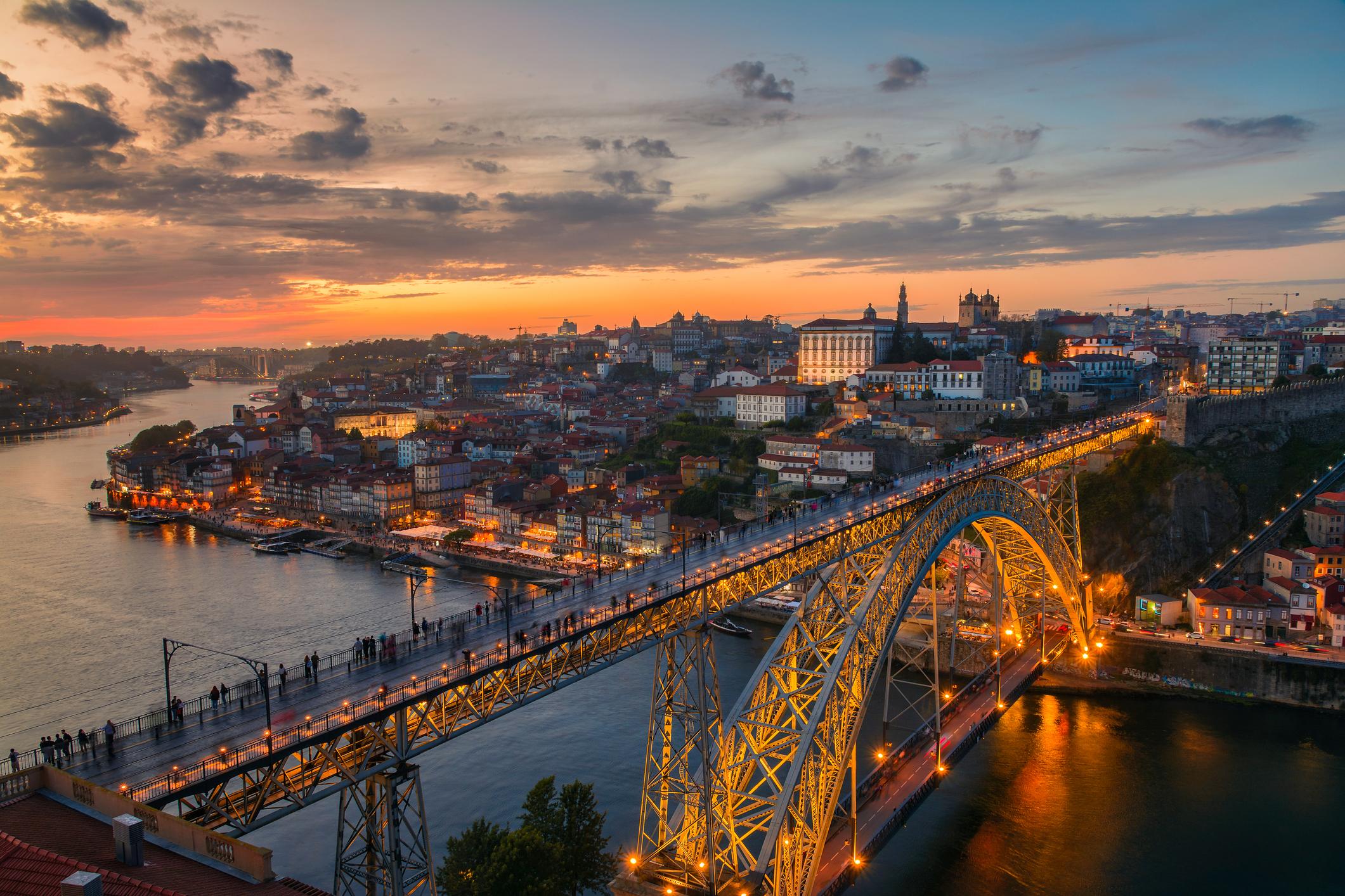 Dom Luis bridge illuminated and Duero riber at sunset, Porto, Portugal.