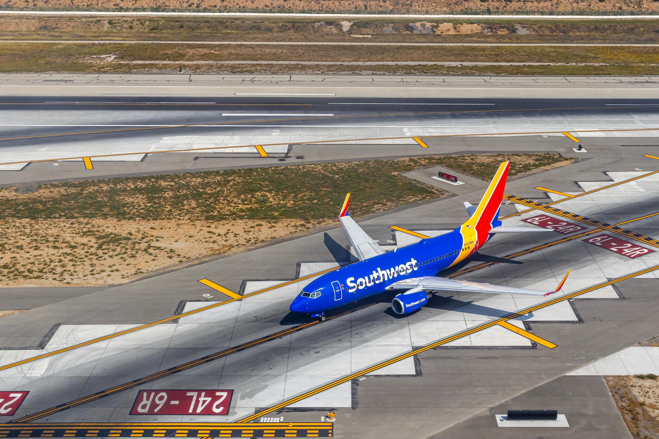 Aerial view of a Southwest Airlines airplane taking off or landing on an airport runway, high angle view of a plane preparing for takeoff