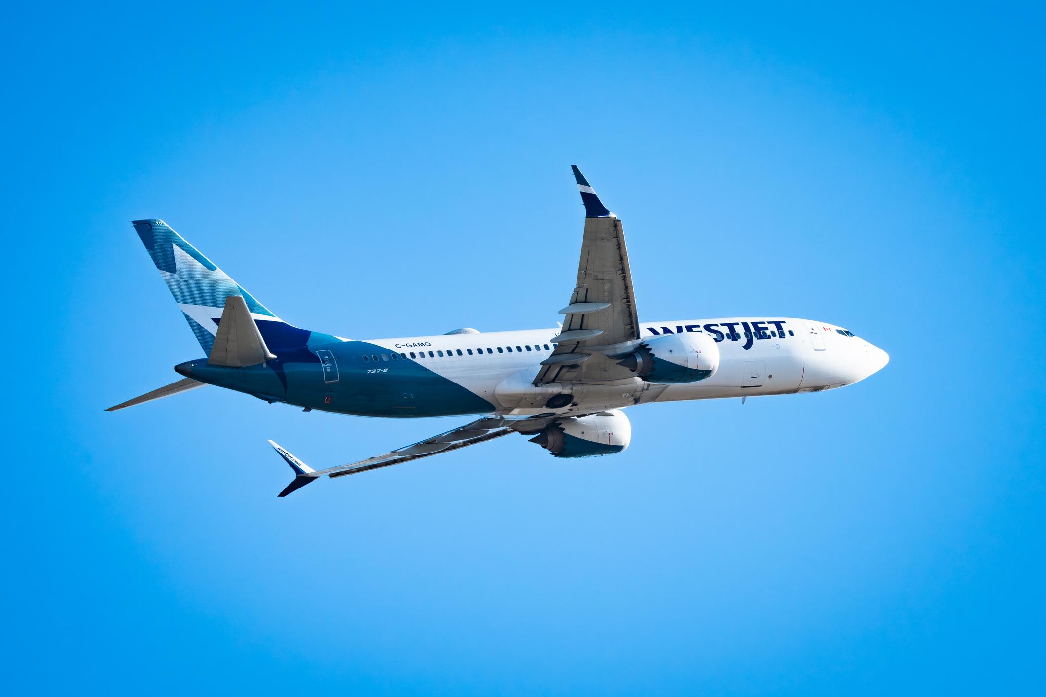 Westjet Airlines plane departs Calgary YYC airport with a blue sky background